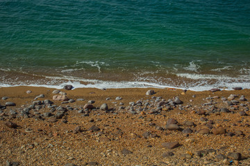 simple colorful wallpaper pattern scenery landscape of horizontal dead sea sand and stone beach shoreline with empty copy space for your text or inscription, travel and summer vacation photography 