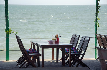 A table with chairs in a cafe under a canopy on the beach. View from the cafe on the Pacific Ocean. Mui Ne village, Province of Binh Thuan, Phan Thiet, Vietnam.