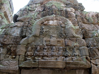Bas-relief with stone sculptures of Buddha and Apsara dancers in Ta Prohm temple, Angkor, Cambodia