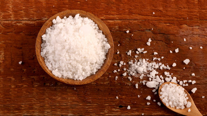 Fototapeta na wymiar Top view of Salt or sea salt in a wooden bowl on a aged wooden table background.
