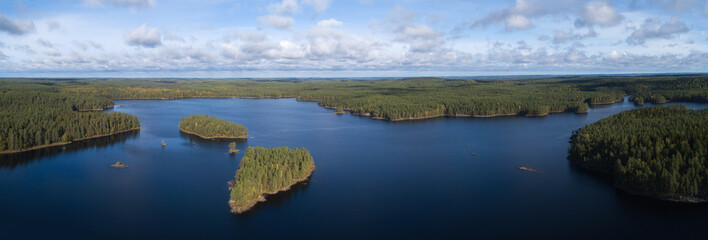Beautiful panorama of the lake and forest. Islands and blue sky with clouds. Finnish National park Helvetinjarvi. 