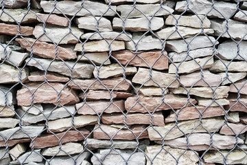 Gabion fence with stones and twisted thick wire. Background. - 253618371