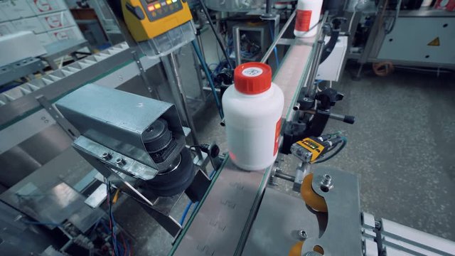Plastic bottles with chemicals are getting polished by a machine