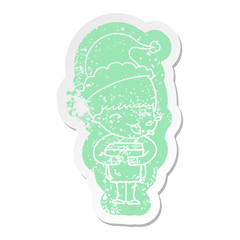 cartoon distressed sticker of a boy wearing santa hat