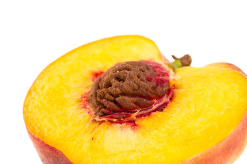 Close up half of a peach with pit isolated on white