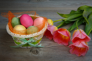 Multi-colored Easter eggs and sweets in a beautiful basket.