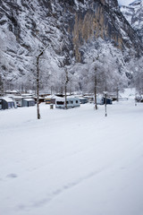 Winter camping with caravan. Camp site in the snow. Camping and travel in Switzerland. Frozen temperatures in the holiday.