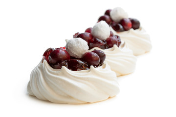 Mini Pavlova meringue nests with fresh and sugared cranberry isolated on white