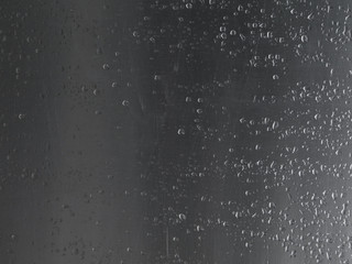 Close up rain drops on scratched aluminium metal sheet.