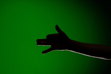 Human hand, isolated on a red background showing the dog's sign, symbolizing the friendship of the animal and man