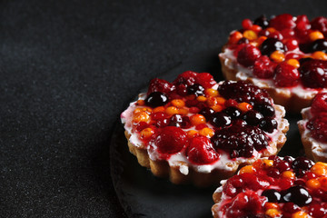 tart with berries close up on dark background