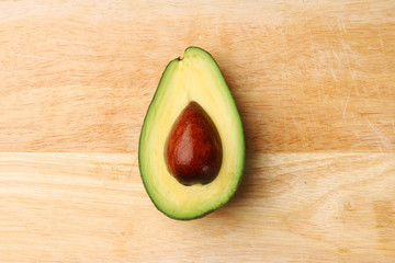 half avocado on wooden background top view
