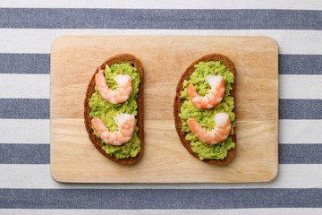 sandwich with shrimp and avocado on wood. breakfast concept