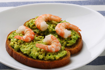 closeup sandwich with avocado guacomole and srimp on white background