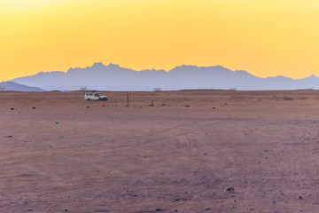 Off road SUV car in Arabian desert at sunset