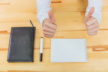 Young women's hands in the office on the table. Showing a gesture class with two hands on a blurry background of the table.