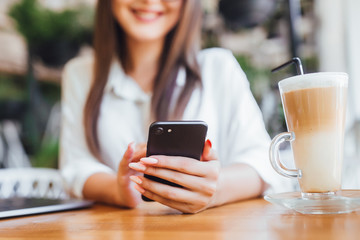 Focus on cup of latte with young girl