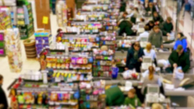 Cashier at supermarket / Retail checkout / Paying groceries. Unrecognizable buyers with carts move in queues to pay for purchases at the supermarket cashier. Fast motion.
