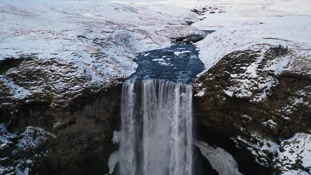 4K Aerial footage of a beautiful waterfall in the snowy mountains