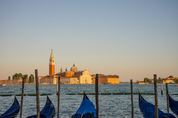 Gondolas moored by Saint Mark square with San Giorgio di Maggiore church in the background in...