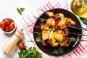 Chicken kebab  with vegetables on skewers on white.