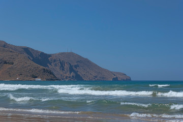Fototapeta na wymiar Sea with small waves in the background of mountains