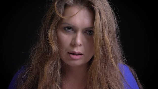 Closeup shoot of adult caucasian brunette female being irritated and furious while looking at camera