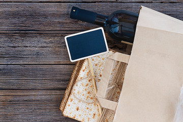 Passover grocery shopping composition with a matzah or matza and red kosher wine in a shopping bag. Top view or overhead view composition with copy space