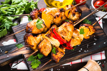 Chicken kebab  on skewers on wooden cuting board. 