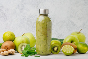 Bottle with green smoothie near ingredients