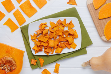 Dried pumpkin slices on white wooden background