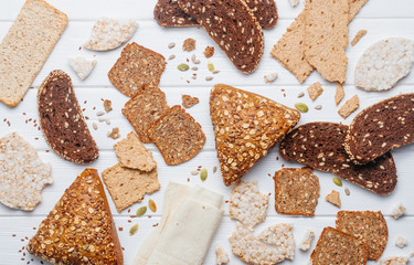 Healthy whole grain bread and crispbreads on wooden background
