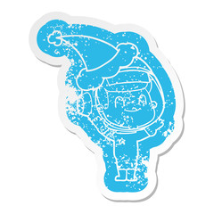 happy cartoon distressed sticker of a astronaut man wearing santa hat