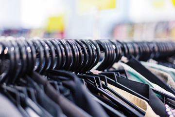 Clothes on hangers in shop. Close up.