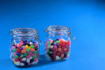 Jars of jelly beans on blue background