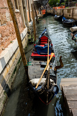 Fototapeta na wymiar The gondolas parked near bridge in Venice, Italy