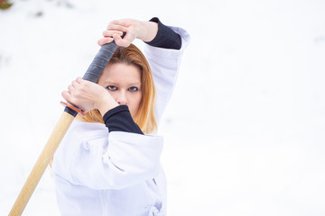 Aikido in the snow. Woman and man fighting in the forest