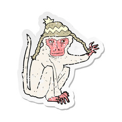 retro distressed sticker of a cartoon monkey wearing hat