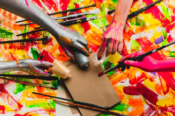 Creative project. Beautiful background. Art. The collective. Teambuilding. Four colored hands. Multi-color photo. Central composition. Filling the space. Work and fun.