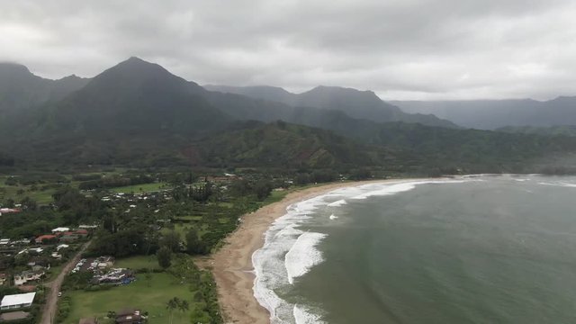 Aerial, mountains overlook beach town in Hanalei Bay, Hawaii