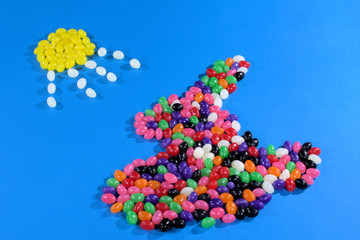 Easter bunny made from jelly beans with sunshine on blue background