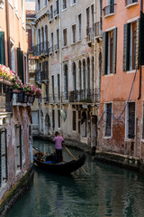 Obraz na płótnie Canvas Italy, Venice, Gondolier navigating a gondola near San Moise on a canal