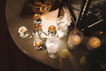 Coziness and style. Modern event design. Table setting at wedding reception. Floral compositions with beautiful flowers and greenery, candles, laying and plates on decorated table.