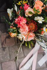 Botanic bridal chic. Beautiful bouquet of spring seasonal flowers with silk ribbons.