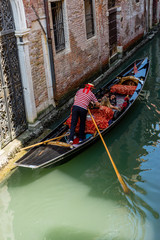 Fototapeta na wymiar The gondolas on a canal in Venice, Italy
