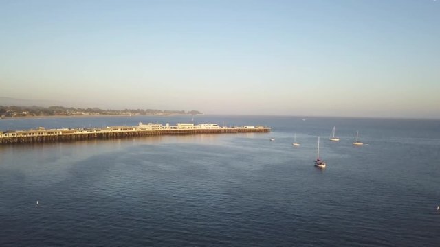 Wide aerial, boats in water by pier in Santa Cruz, California