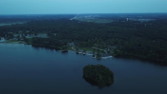 Wide aerial, woods at edge of lake in Milford, Michigan