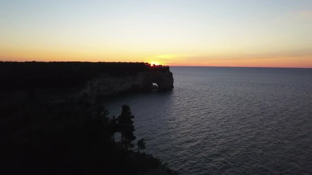 Cliffs over water at sunset in Munising Township, Michigan, aerial