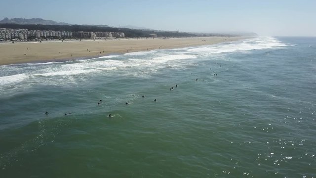 Aerial, surfers await waves at beach in San Francisco, California