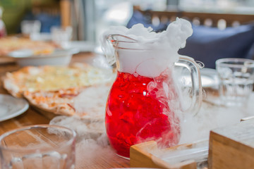 Cold juice with steam and smoke on birthday party table
